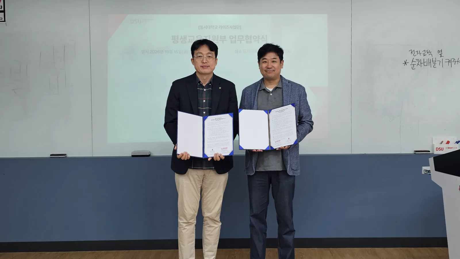한국마술진흥협회과 동서대학교 관계자가 2026년 10월 16일 업무협약서를 들고 기념촬영을 하고 있다.